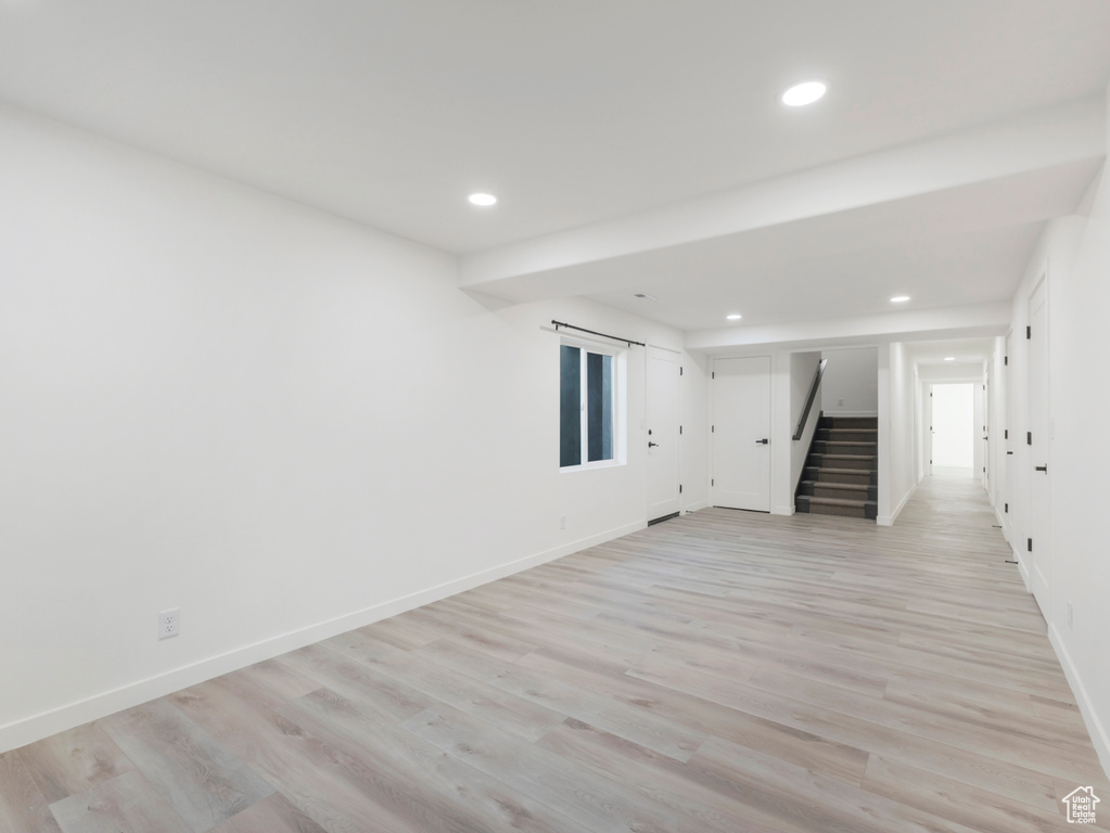 Empty room with stairs, recessed lighting, baseboards, and light wood-type flooring