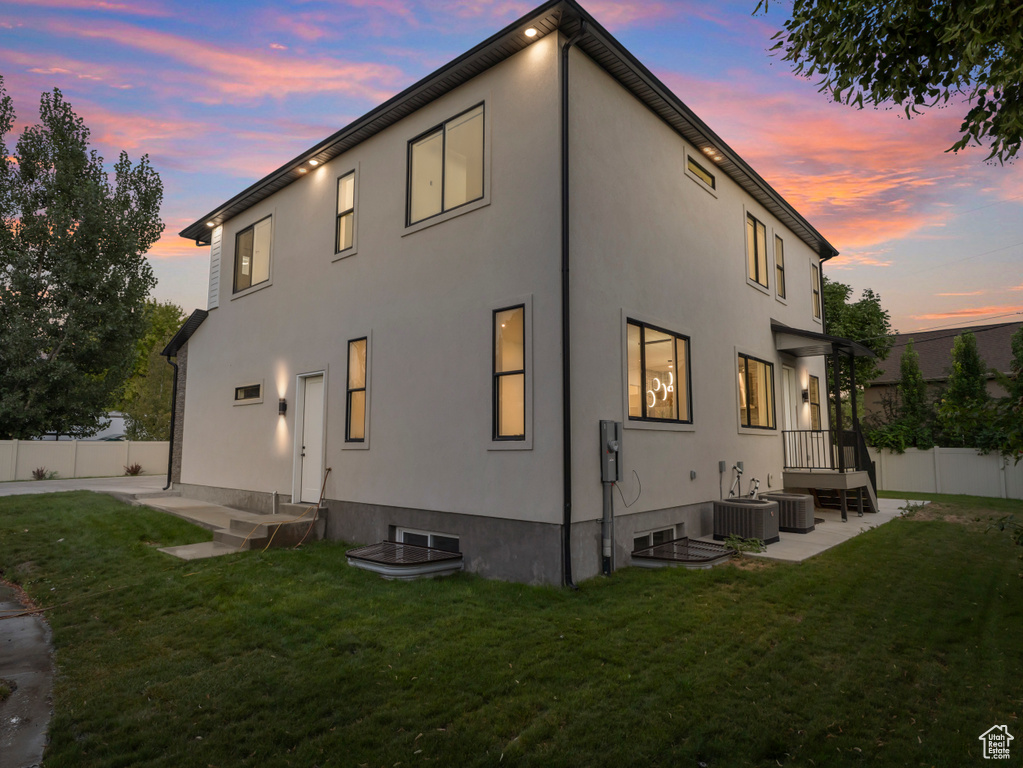 Back of property featuring stucco siding, central air condition unit, and a patio area