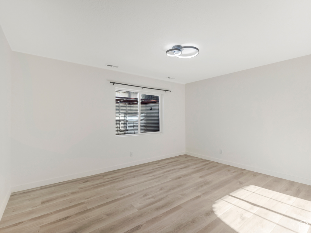 Empty room featuring light wood-type flooring and baseboards