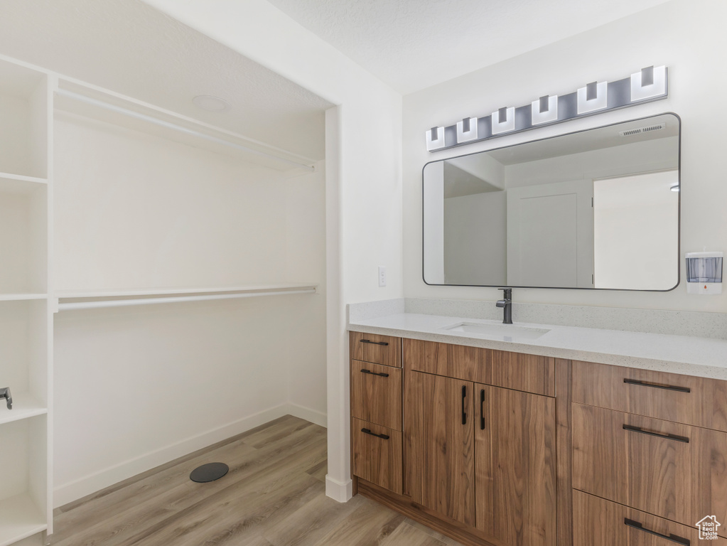 Bathroom with wood finished floors, vanity, and baseboards