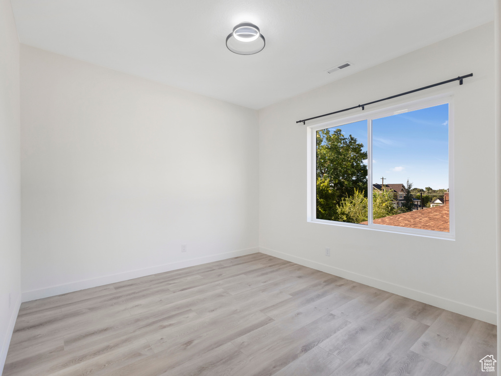 Unfurnished room with light wood-style floors and baseboards