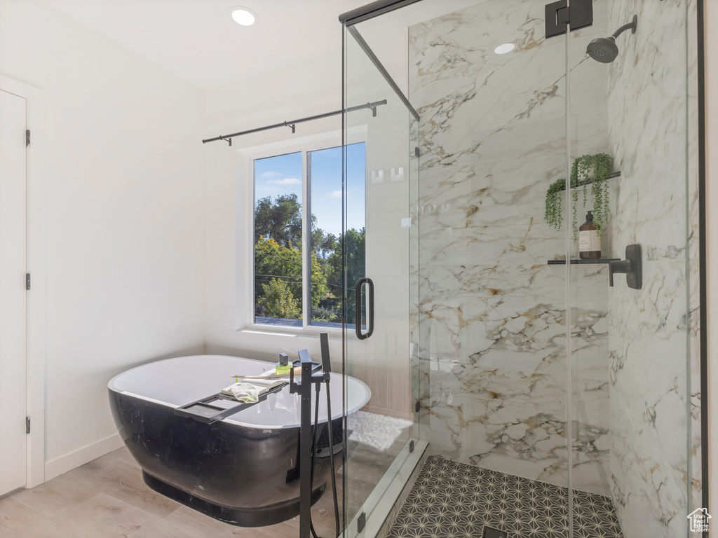 Bathroom with a soaking tub and a marble finish shower