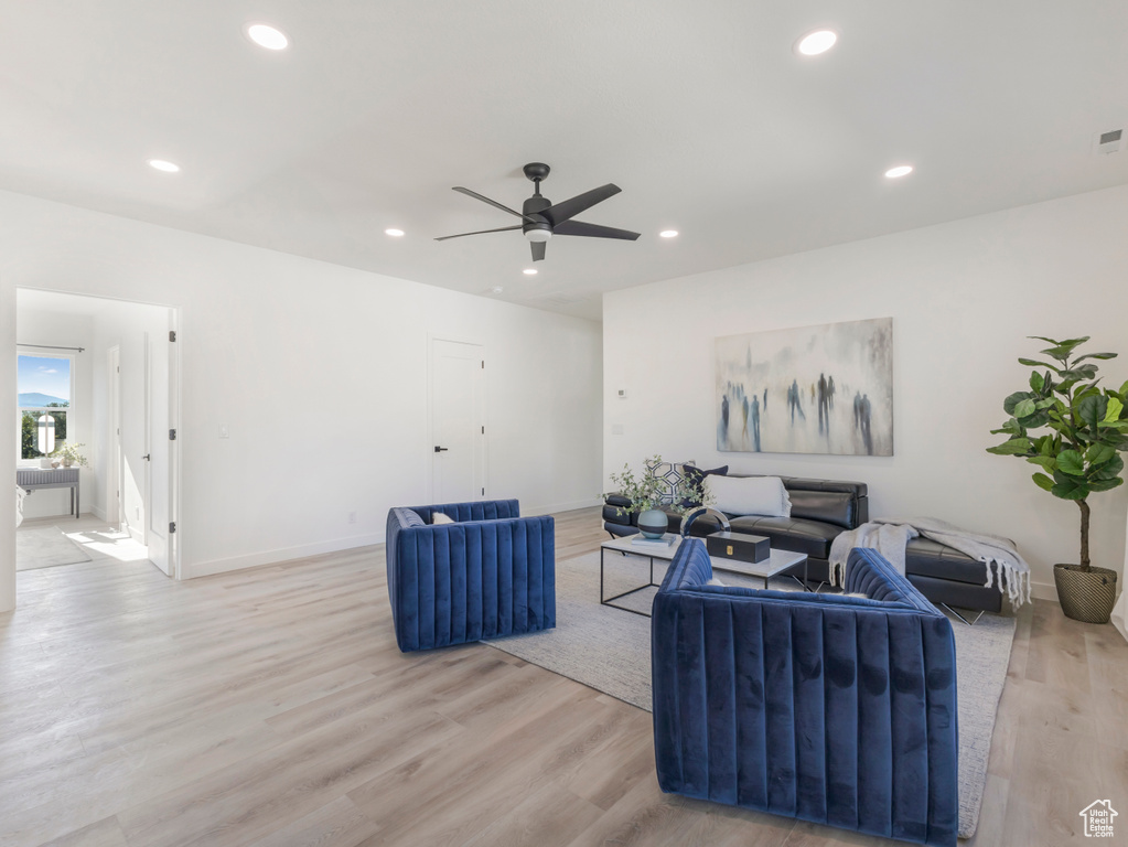 Living area featuring light wood-type flooring, a ceiling fan, recessed lighting, and baseboards