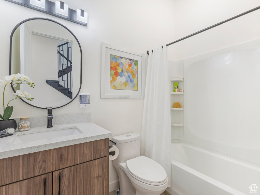 Full bathroom with toilet, vanity, and shower / tub combo with curtain