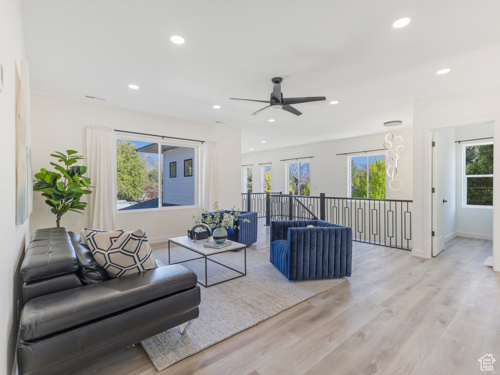 Living area featuring recessed lighting, ceiling fan, light wood finished floors, and baseboards