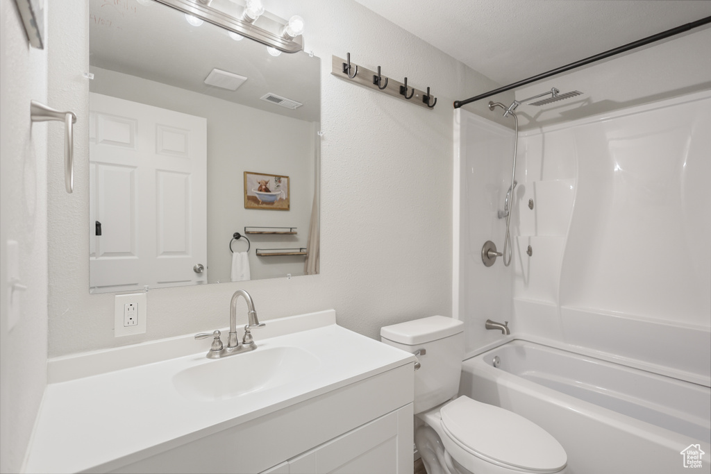 Full bathroom with toilet, vanity, and washtub / shower combination