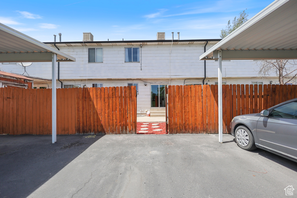 View of front facade featuring covered parking and fence