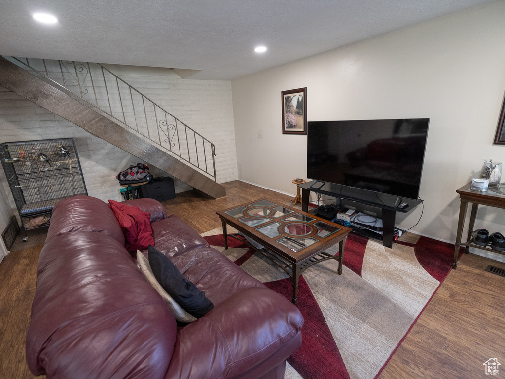 Living area featuring stairway, baseboards, recessed lighting, and wood finished floors