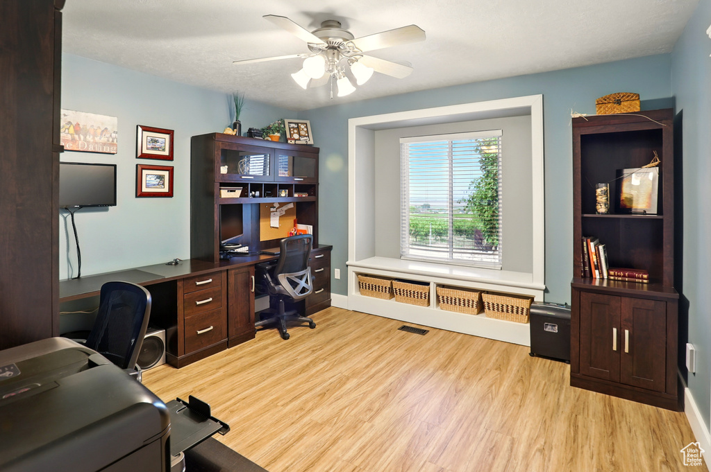 Office space featuring light wood-style floors, ceiling fan, and baseboards
