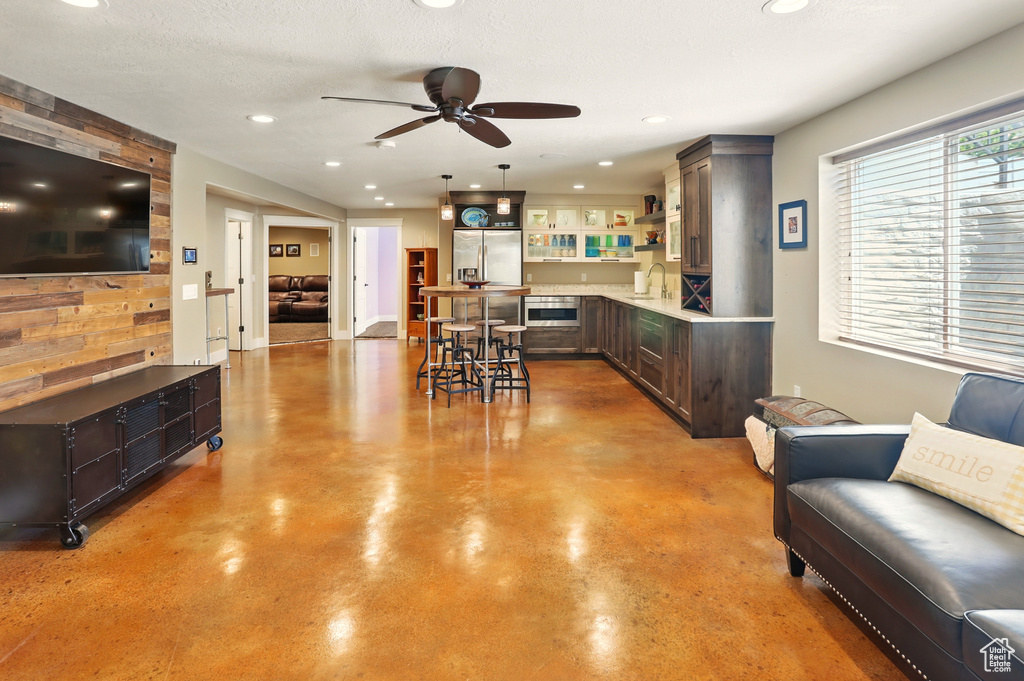 Dining area with finished concrete flooring, ceiling fan, and recessed lighting
