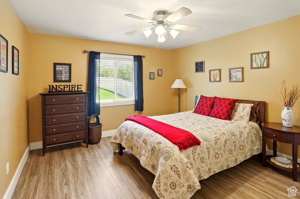 Bedroom featuring wood finished floors, baseboards, and ceiling fan