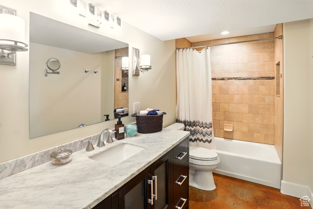 Bathroom with toilet, finished concrete floors, vanity, and shower / tub combo
