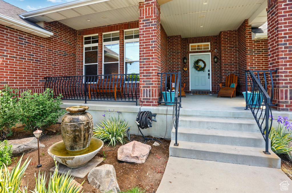 Property entrance with brick siding and a porch