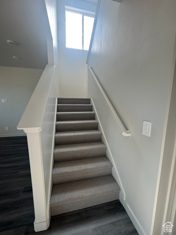 Staircase featuring wood finished floors and baseboards