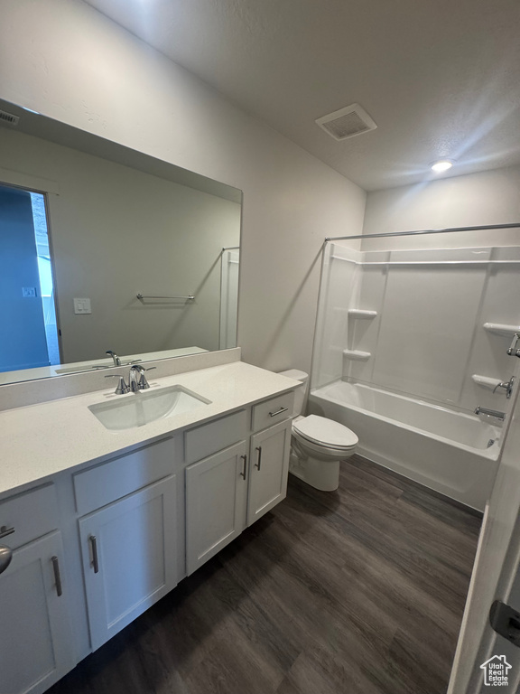 Full bath with wood finished floors, vanity, and bathtub / shower combination