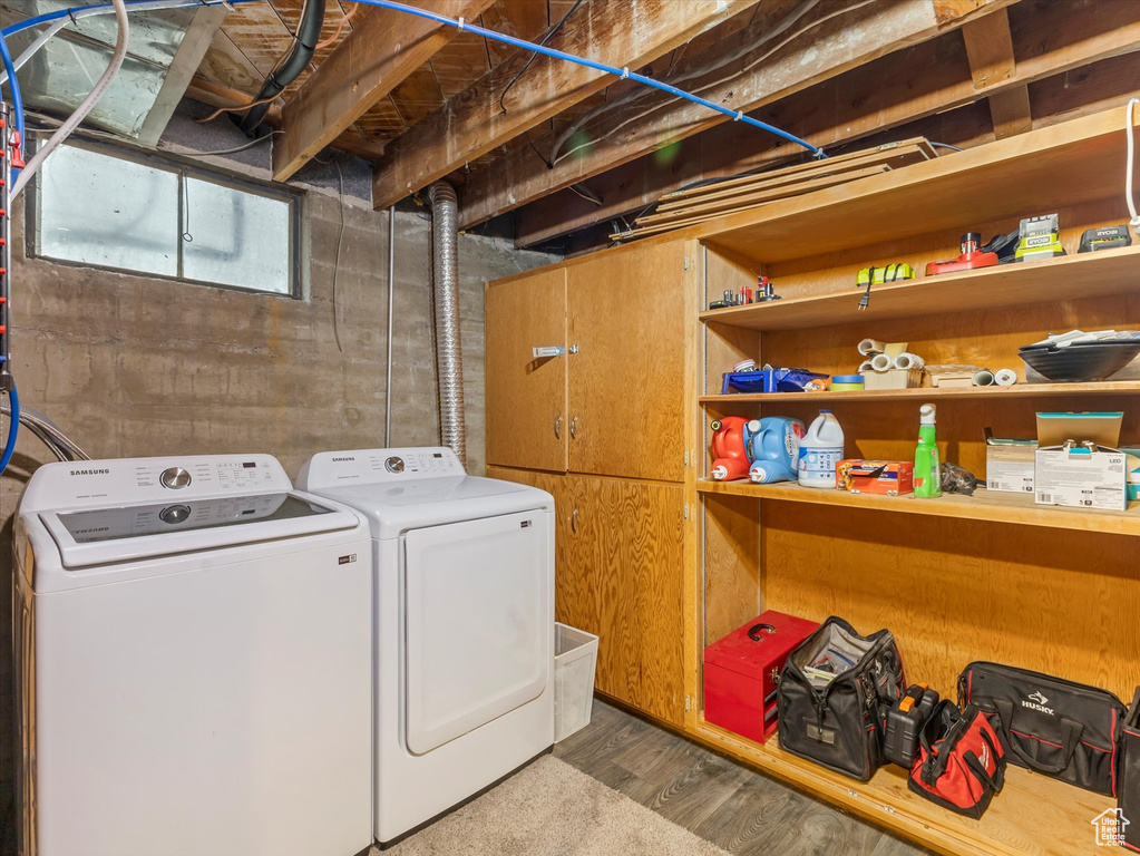 Laundry room featuring washing machine and clothes dryer and wood finished floors