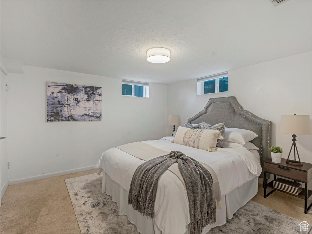 Bedroom featuring light colored carpet and baseboards