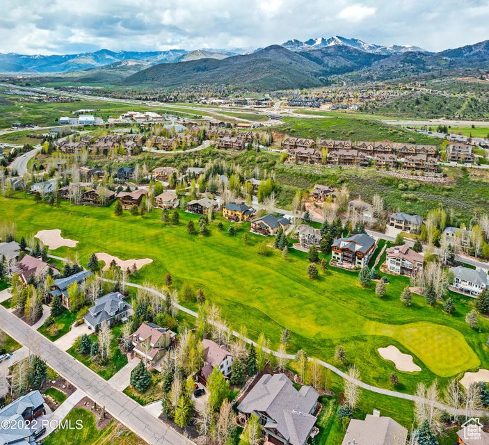 Aerial view of residential area with a mountain backdrop and a golf course