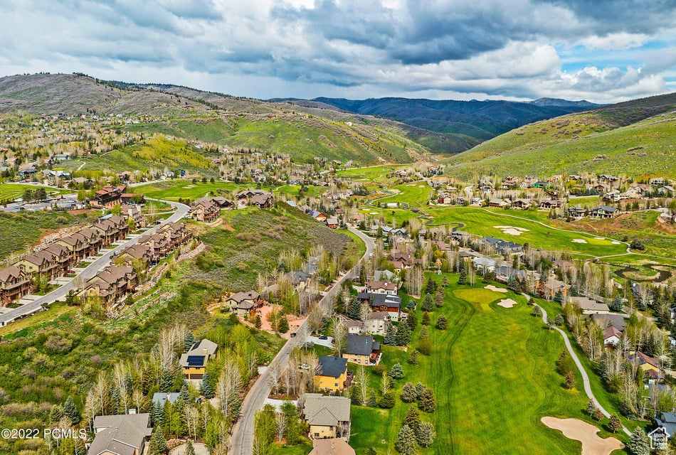 Aerial view of residential area with a mountain backdrop and a golf course