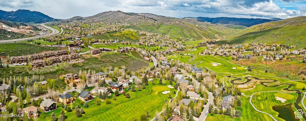 Aerial perspective of suburban area featuring mountains and a golf club