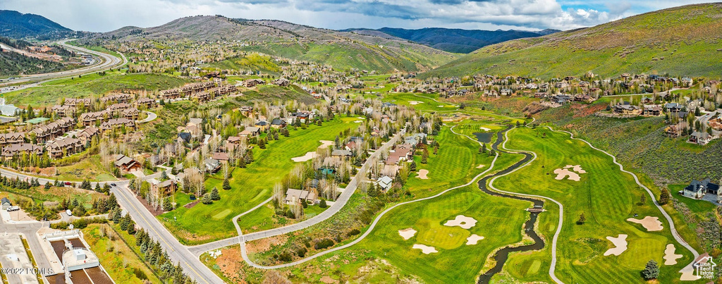 Aerial perspective of suburban area with a mountain backdrop and a local golf course