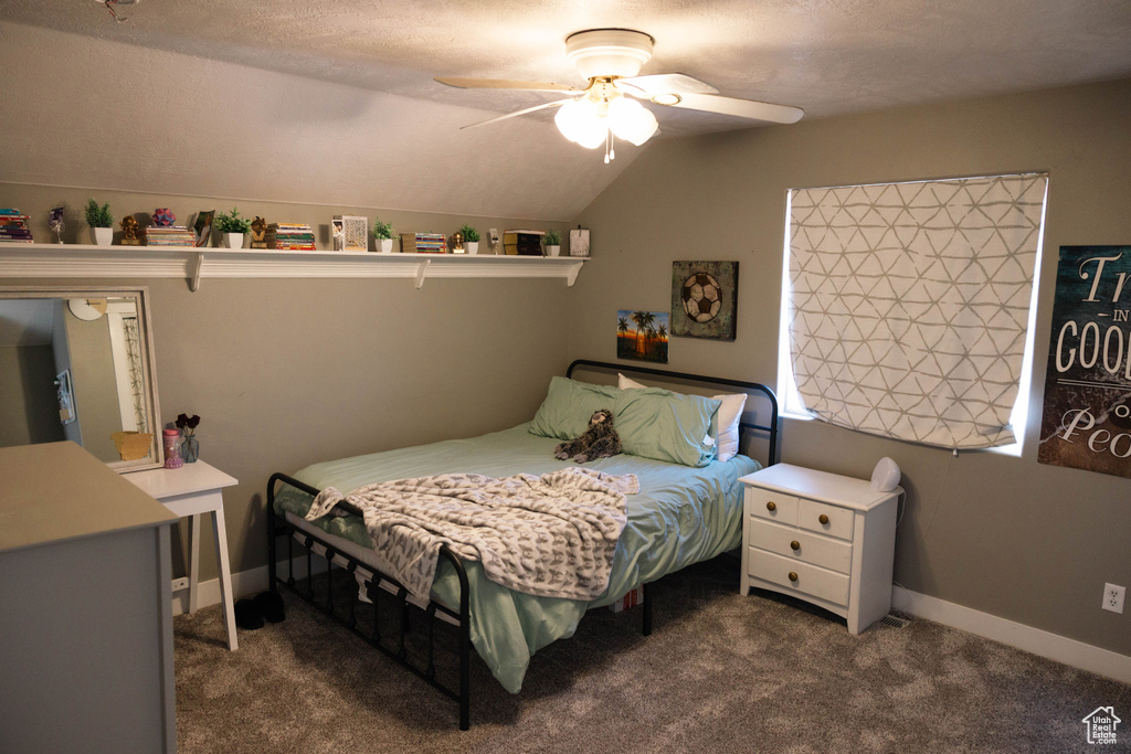 Bedroom featuring dark carpet, lofted ceiling, ceiling fan, and baseboards