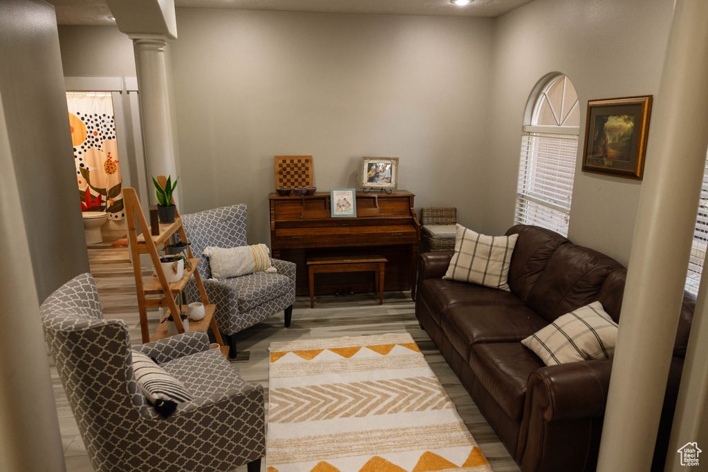 Living area featuring ornate columns and light wood-style floors
