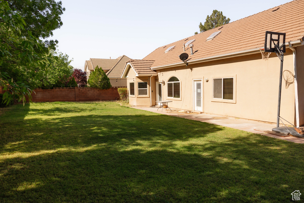 Back of house with stucco siding, a tiled roof, and a patio