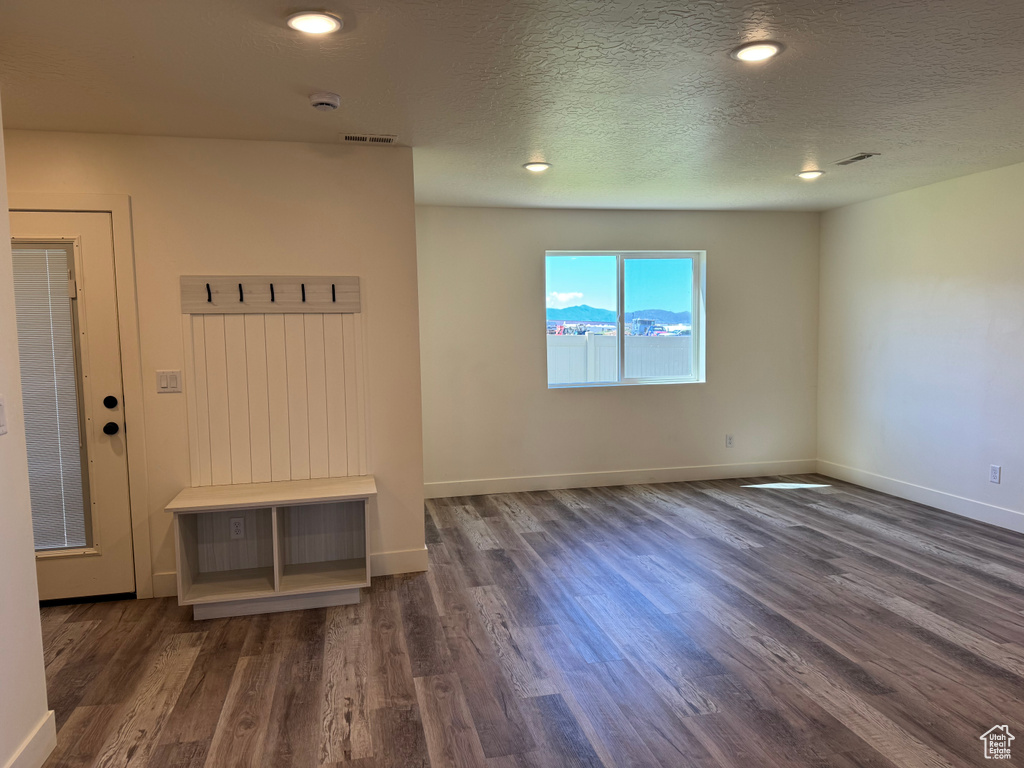 Spare room featuring wood finished floors, baseboards, a textured ceiling, and recessed lighting