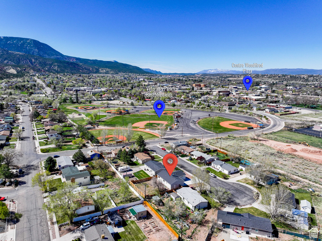 Aerial view of property's location featuring mountains, nearby suburban area, and property parcel outlined