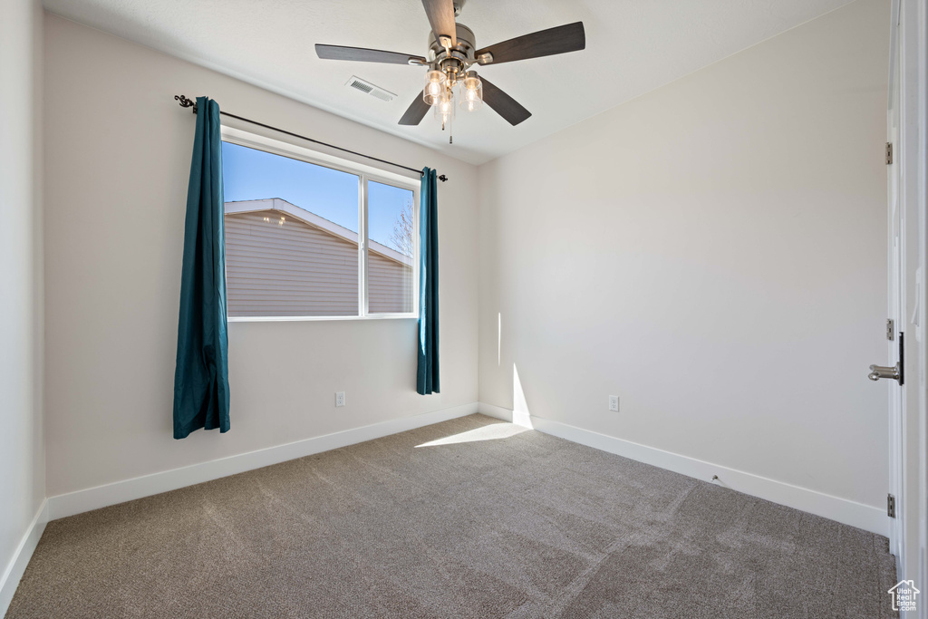 Unfurnished room with carpet, baseboards, and a ceiling fan