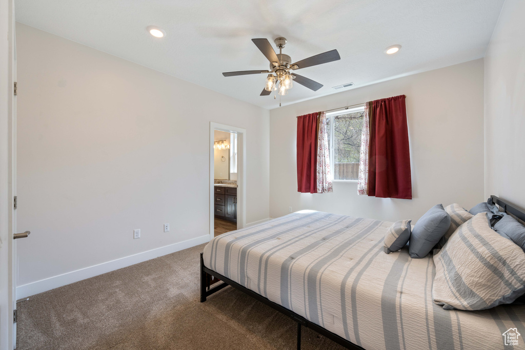 Carpeted bedroom with baseboards, ceiling fan, recessed lighting, and ensuite bathroom