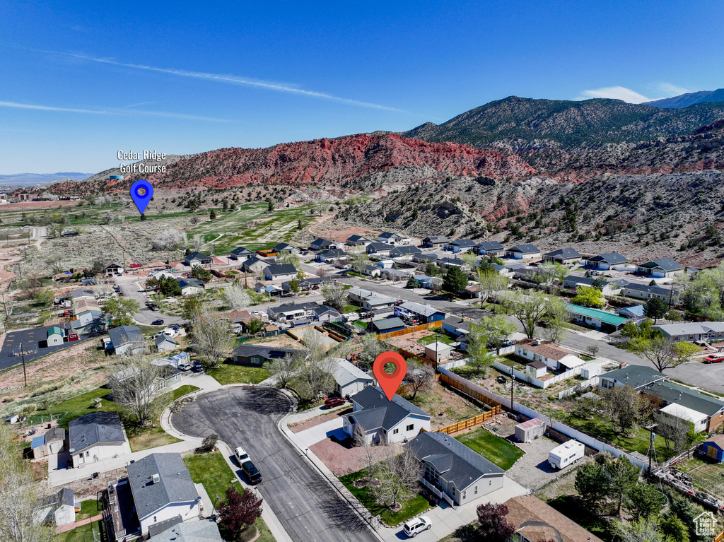 Aerial view of property and surrounding area with a mountain backdrop and nearby suburban area