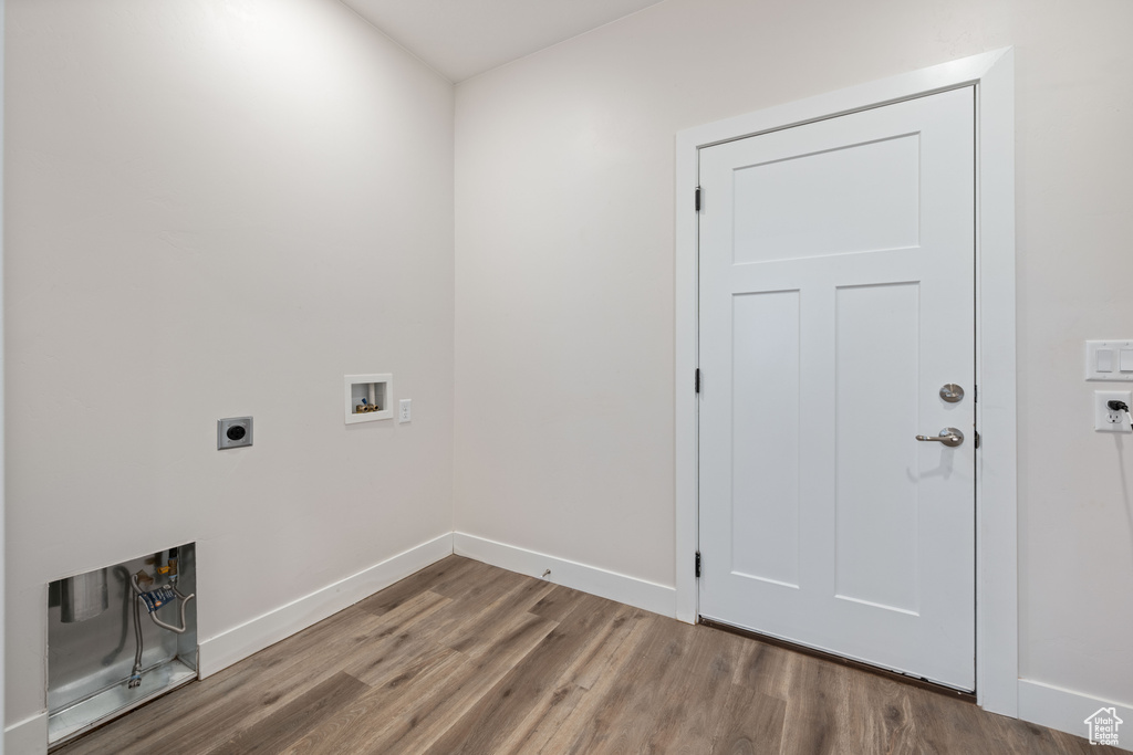 Laundry area with electric dryer hookup, washer hookup, wood finished floors, and baseboards