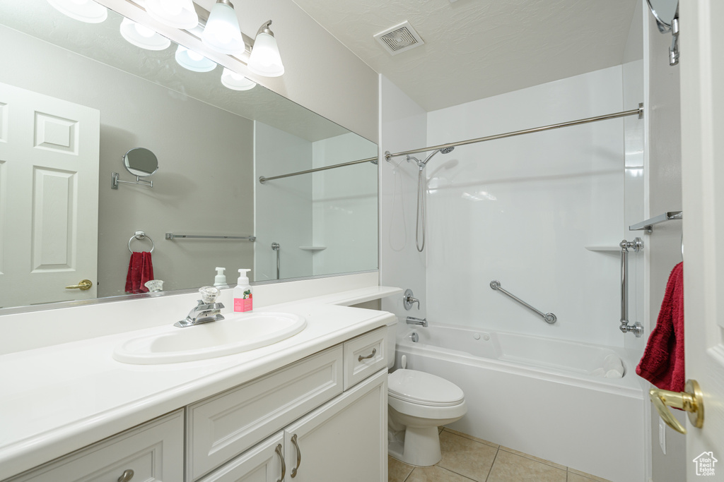 Full bath featuring tile patterned flooring, vanity, toilet, and washtub / shower combination