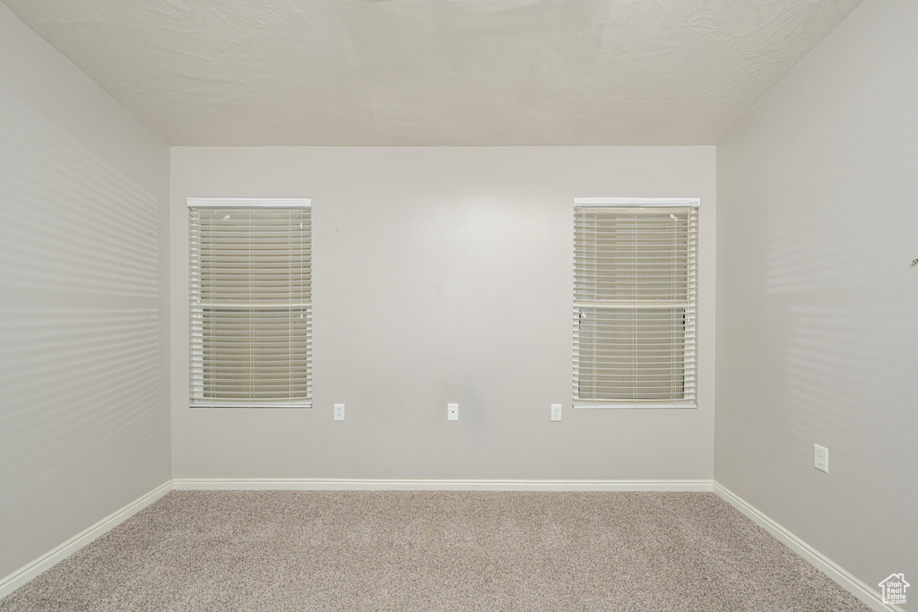 Unfurnished room featuring carpet floors and baseboards