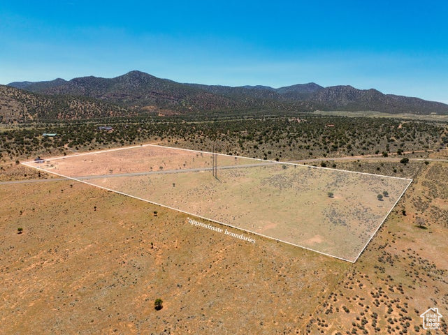 Aerial view of sparsely populated area with mountains, property boundaries highlighted, and a desert landscape
