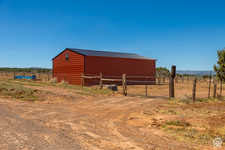 View of pole building with fence, a view of rural / pastoral area, and a mountain view