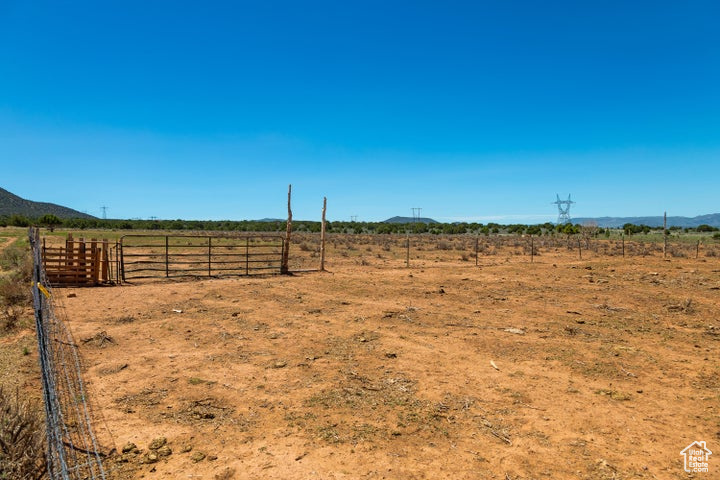 View of yard with a view of rural / pastoral area, fence, and a mountain view