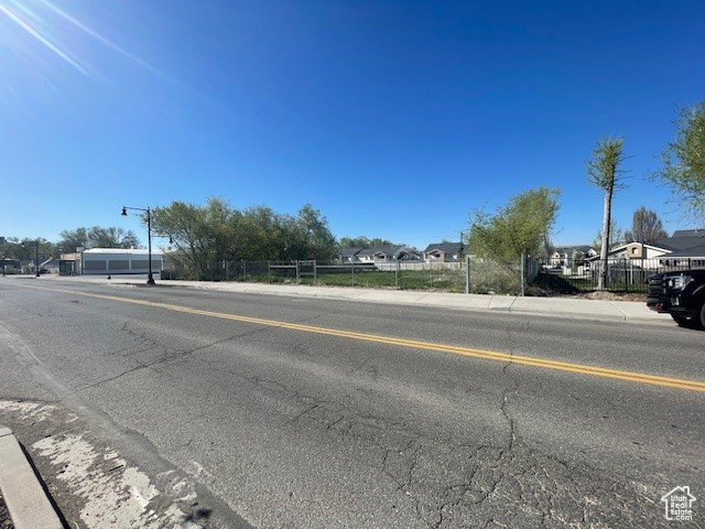 View of asphalt street with sidewalks, a residential view, and curbs