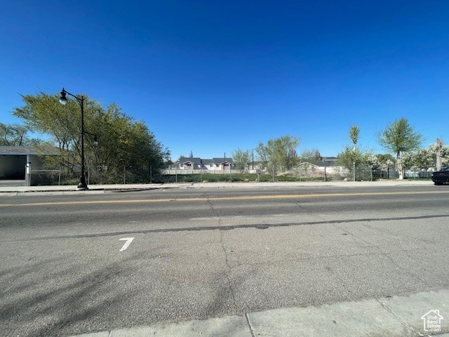 View of asphalt street with sidewalks, street lights, and curbs