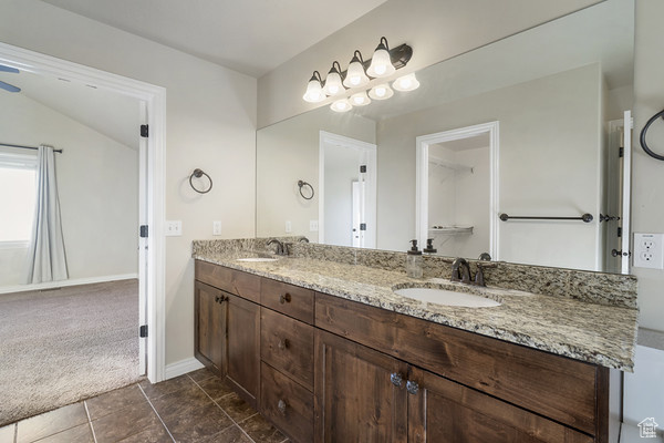 Full bathroom with double vanity and baseboards