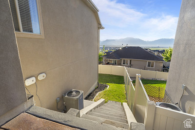 View of home\\\'s exterior with a mountain view, fence, and stucco siding