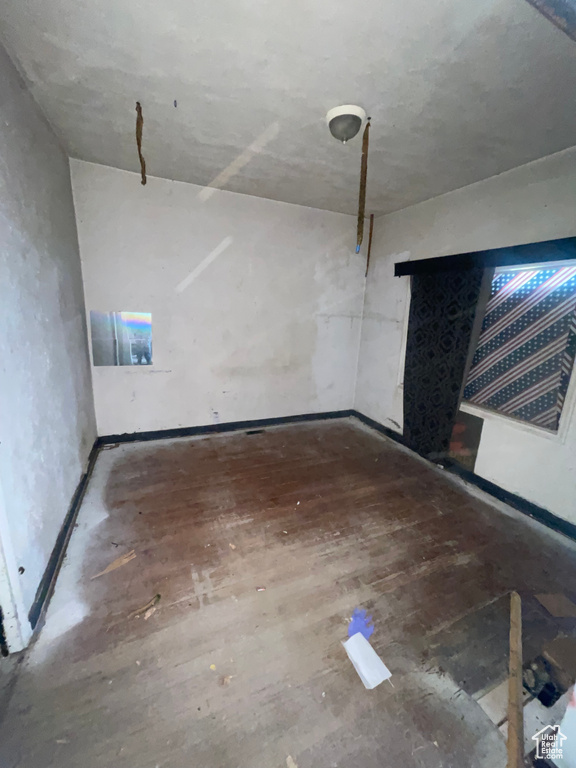Unfurnished living room with baseboards and wood finished floors