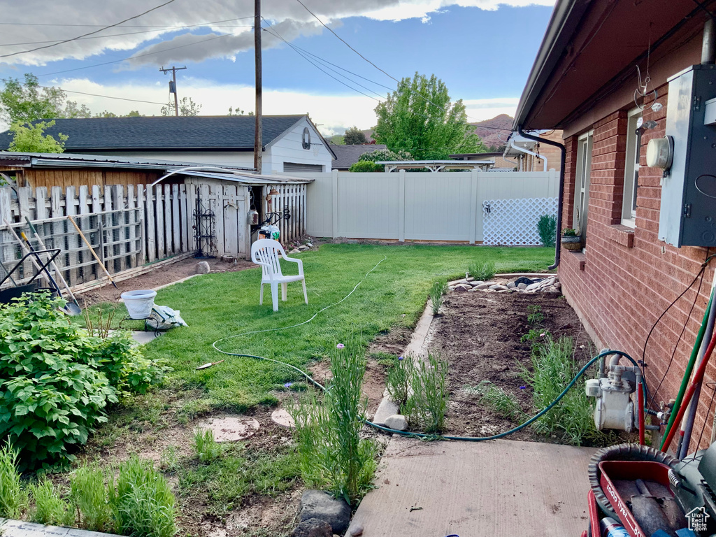 View of yard with a storage shed and an outbuilding