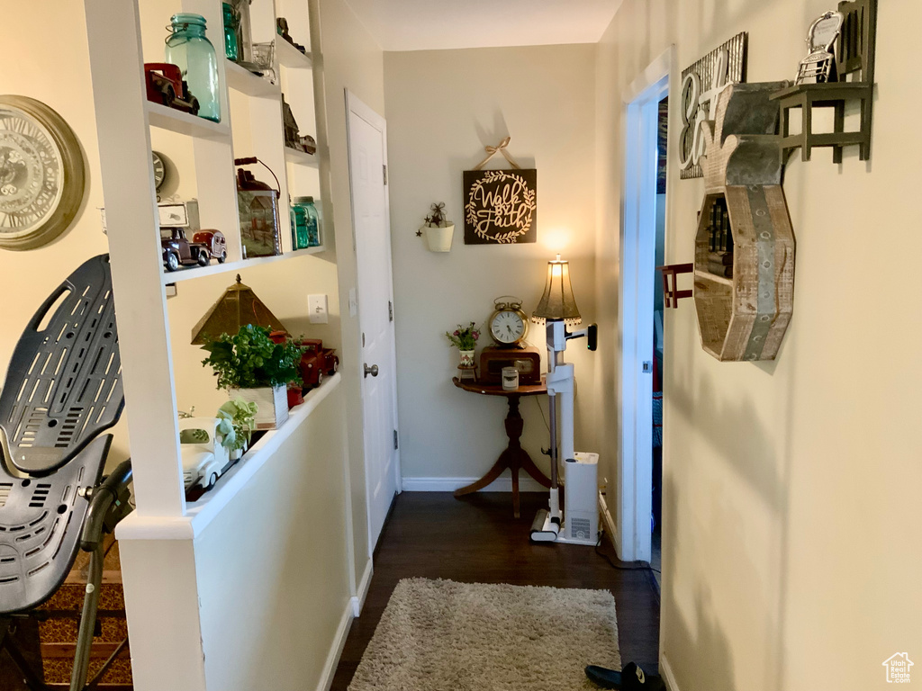 Hallway featuring dark wood finished floors and baseboards
