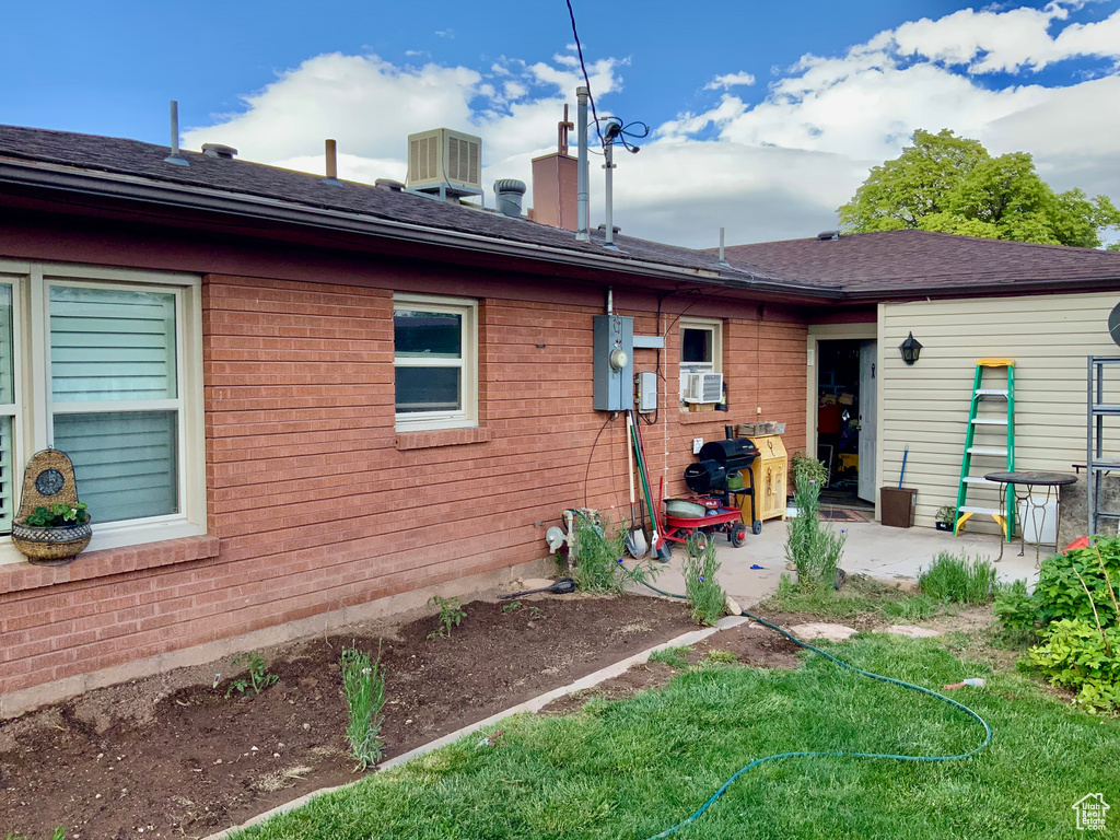 Rear view of house with a patio area, central AC unit, and cooling unit