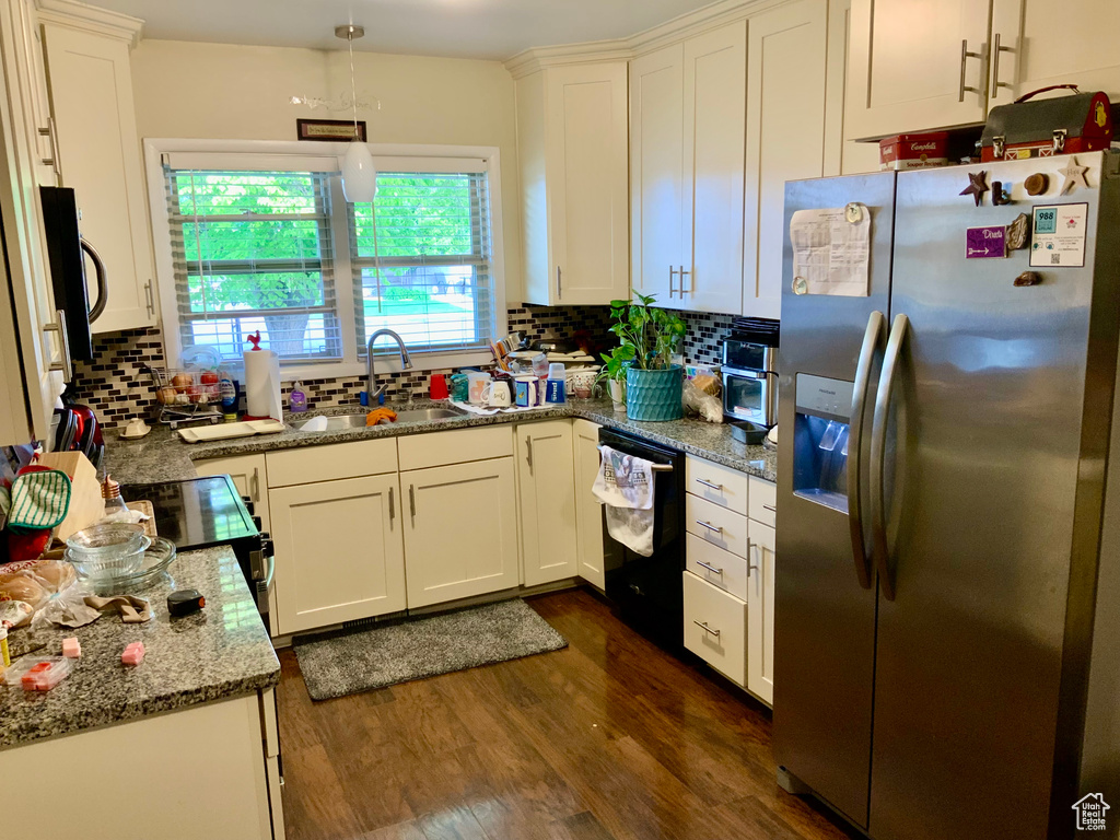 Kitchen with black appliances, a sink, dark wood-style floors, decorative backsplash, and white cabinets