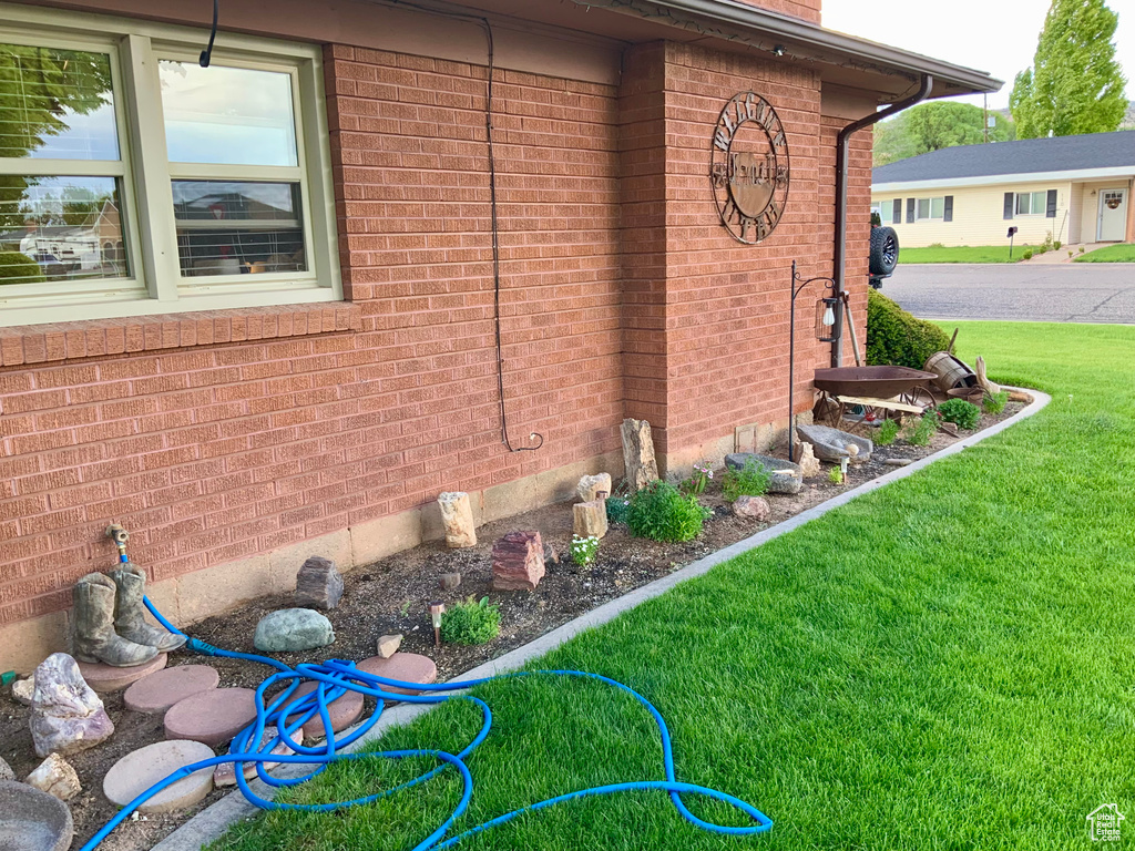View of home\\\'s exterior featuring brick siding and a yard