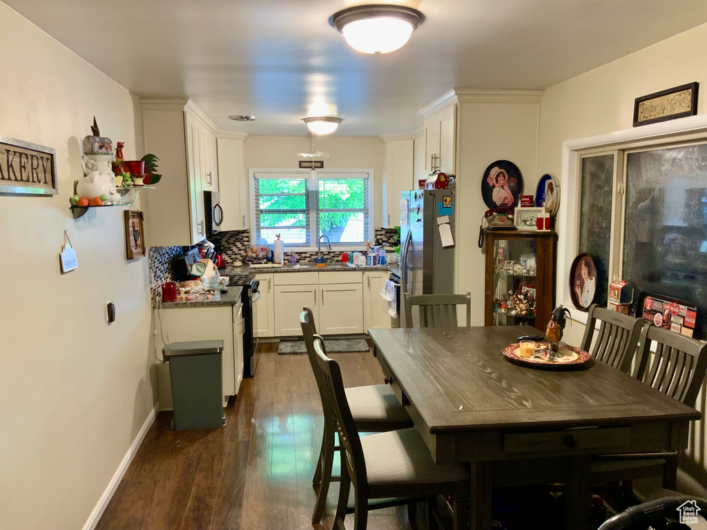 Dining room with dark wood-style flooring and baseboards